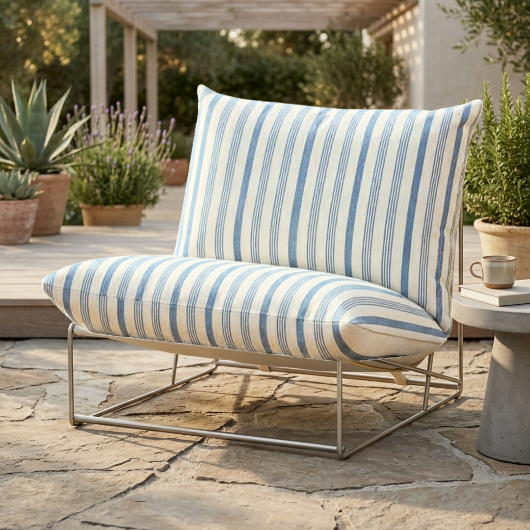 Outdoor chair with blue and white striped cushions on a stone patio