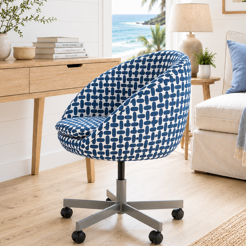 Blue patterned chair in a living room with a desk and ocean view