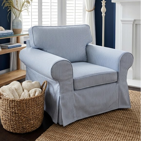 Living room with a blue armchair, wooden side table, and decorative items.