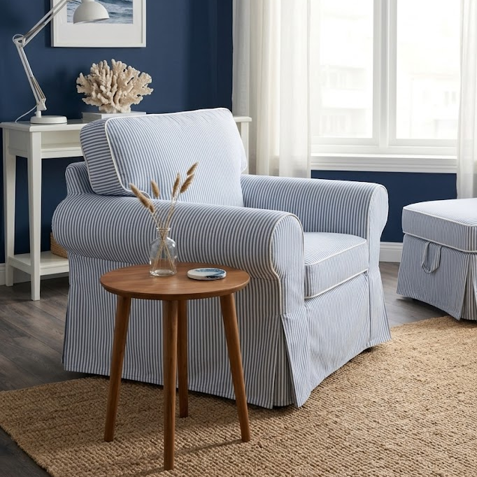 Living room with a blue stripe Ektorp armchair, wooden side table, and blue walls.
