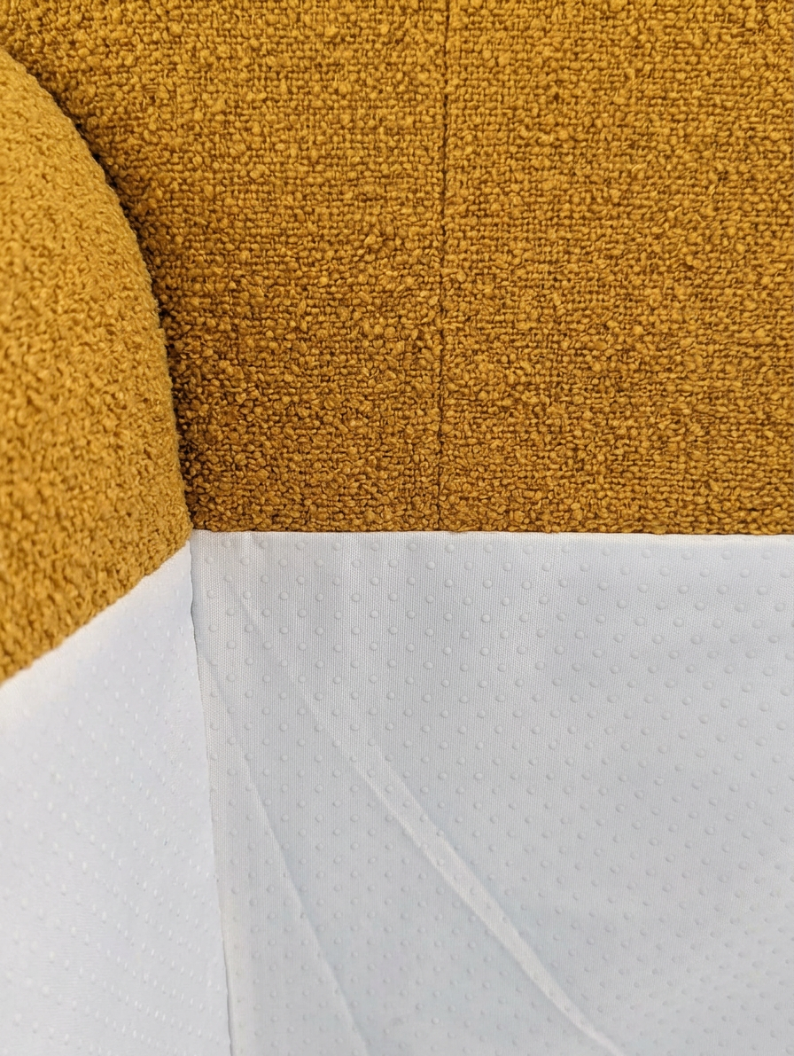 Close-up of a textured yellow fabric surface with a white edge.