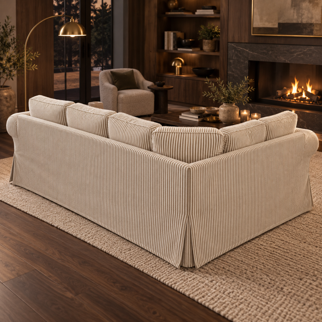 A cream-colored corduroy sectional sofa slipcover with matching back cushions, shown in a styled living room setting with a fireplace, rug, and armchair.