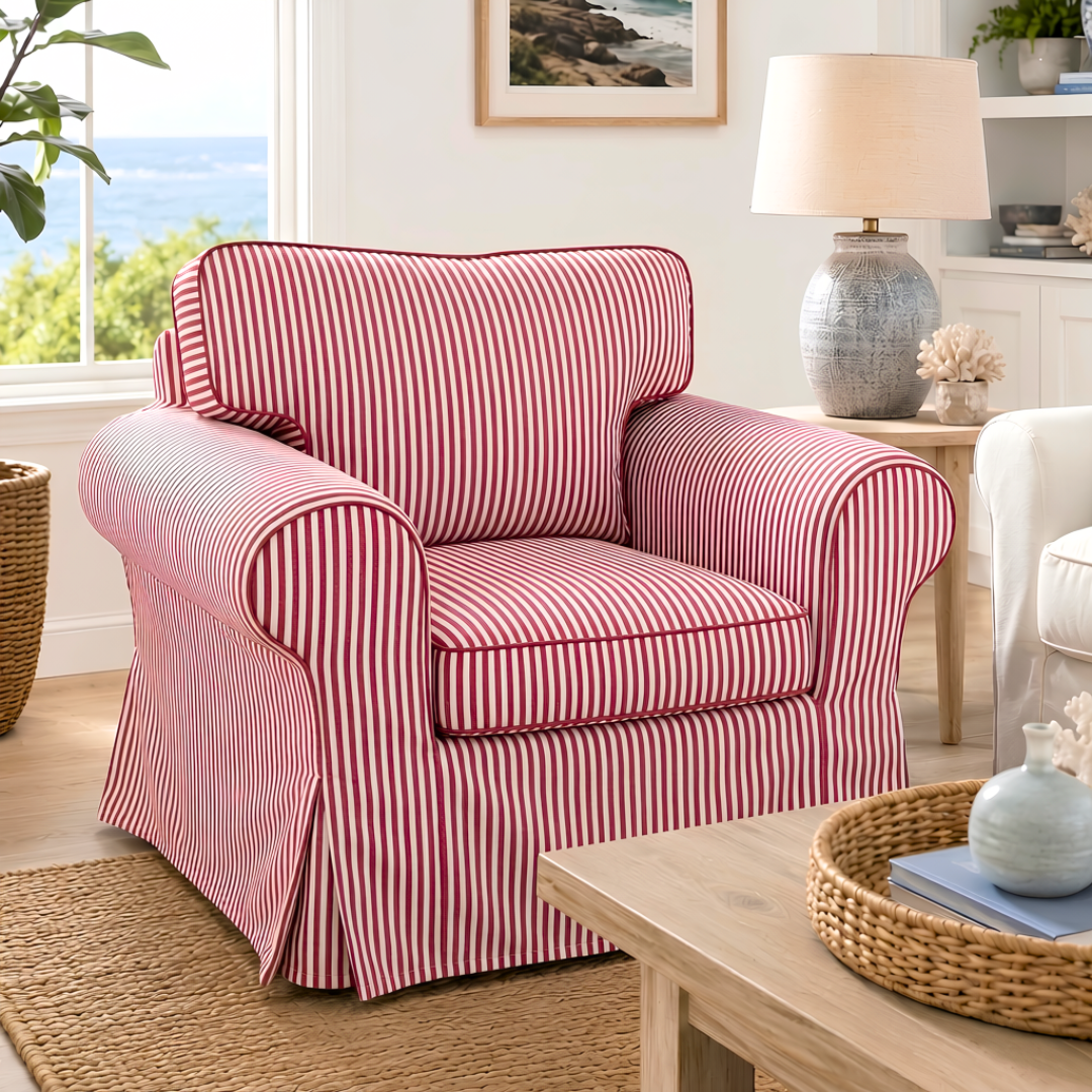 A slipcovered armchair with red and white vertical stripes, styled in a bright, coastal-themed living room.