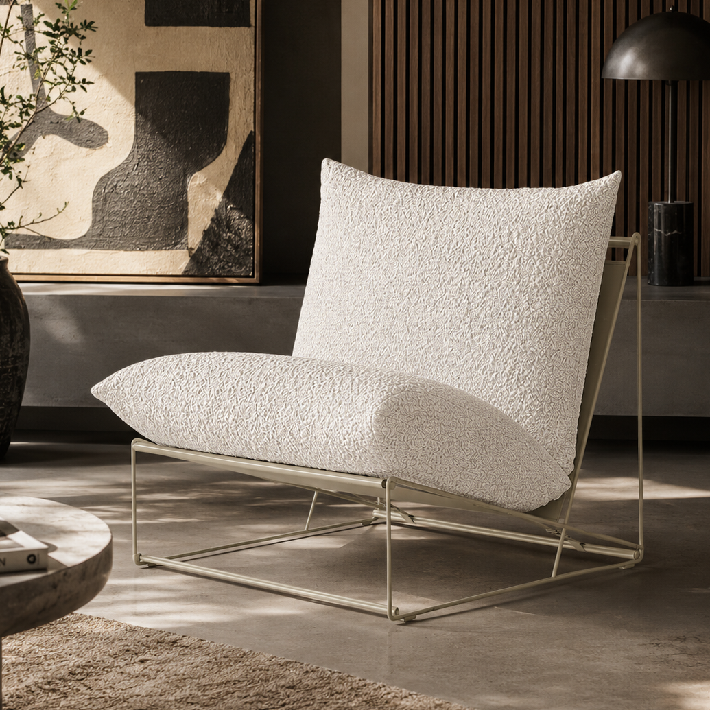 Modern white lounge chair in a stylish room with abstract art and decor.