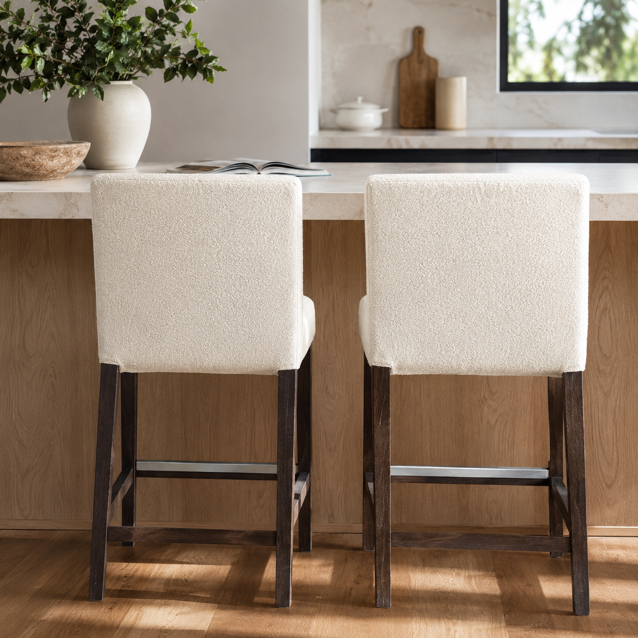 Two beige bar stools with dark wooden legs in a kitchen setting.
