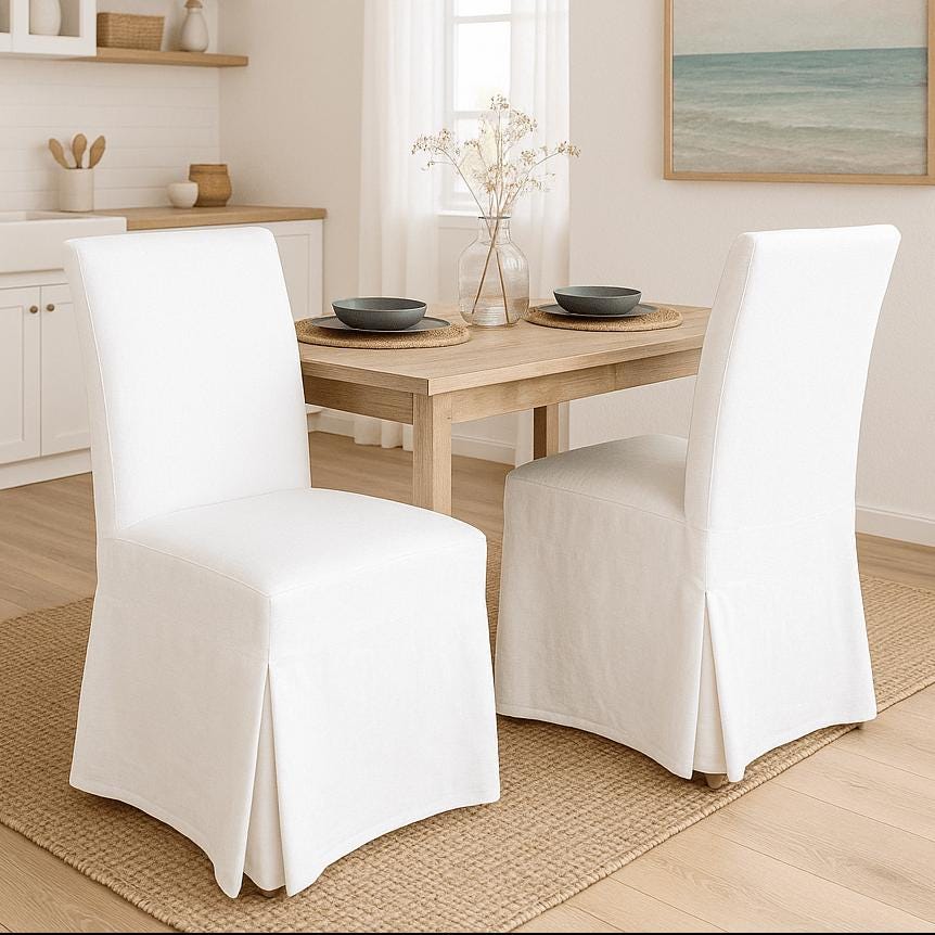 Dining room with white chairs and a wooden table.