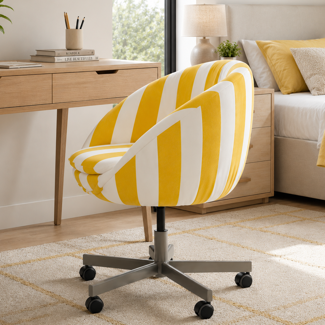 Yellow and white striped office chair in a home office setting with a desk and bed.