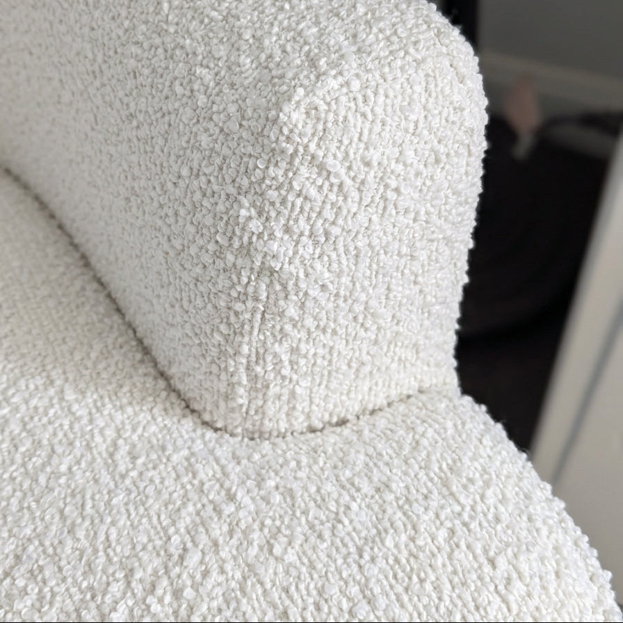 Close-up of a textured white sofa armrest.