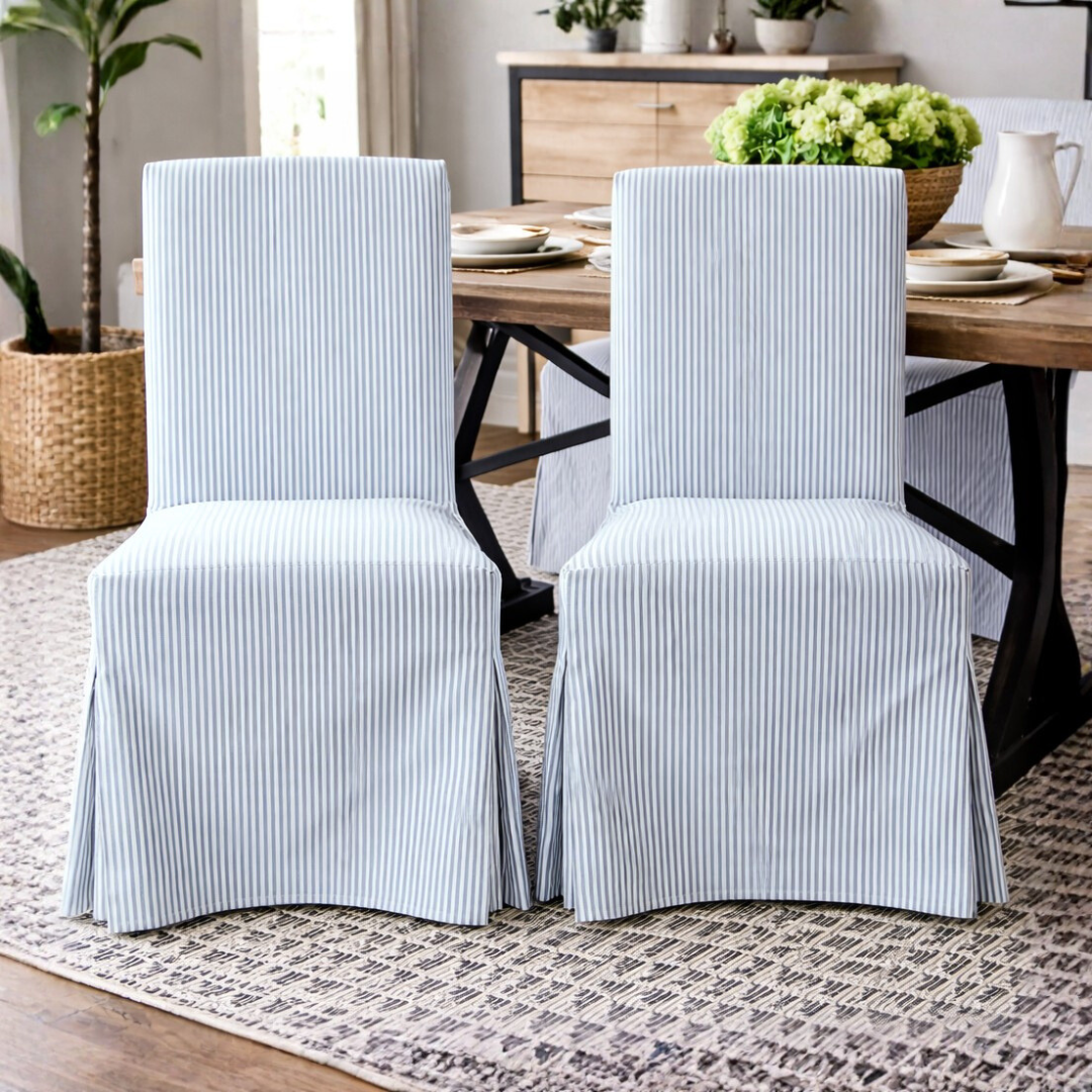 Dining room with striped chair covers on chairs around a wooden table.